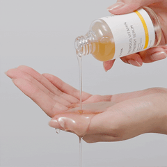 IUNIK Propolis Vitamin Synergy Serum (50ml) texture shot of the serum with a hand catching the serum 